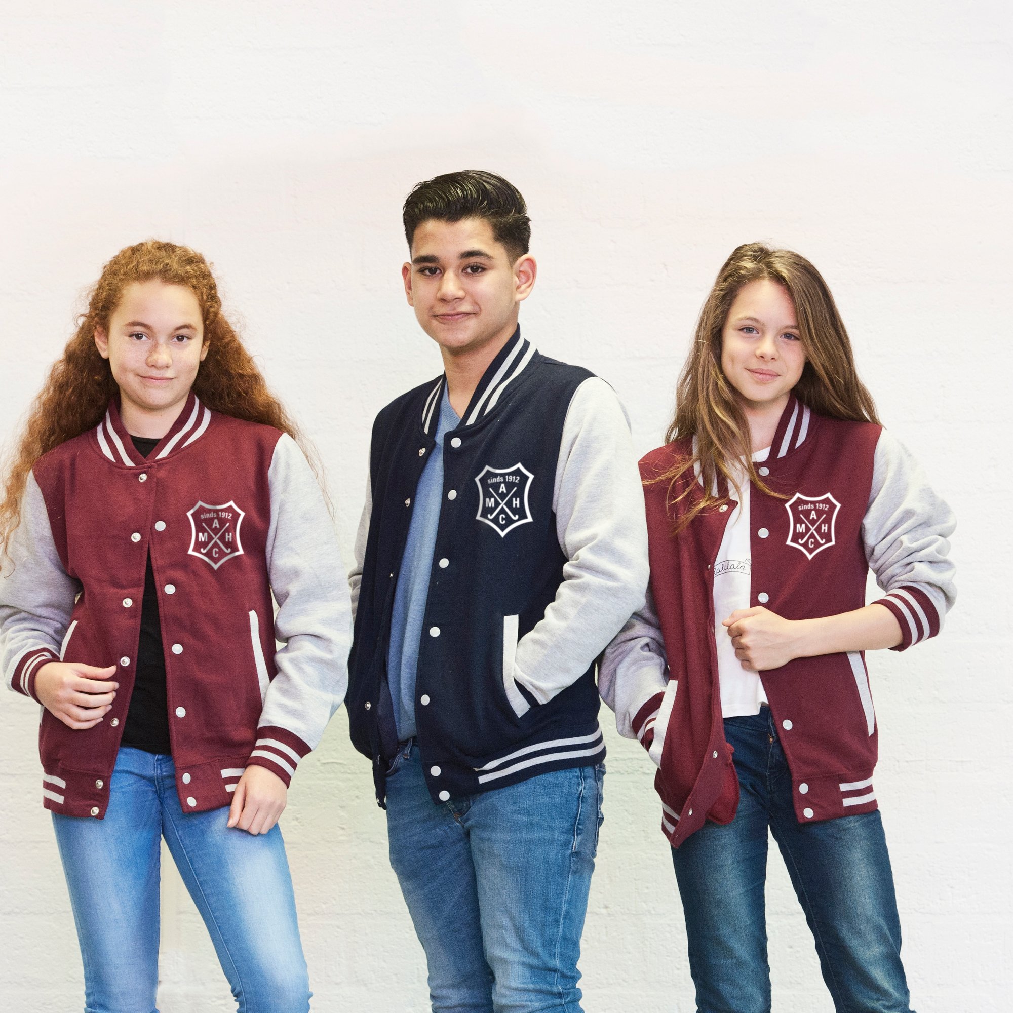 Three young people in baseball vests printed with a club logo