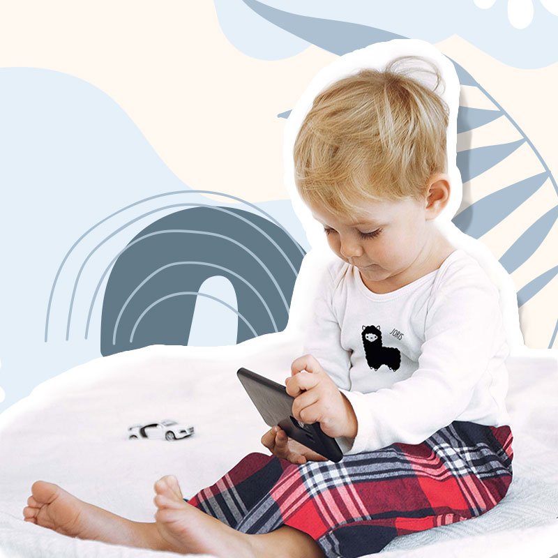Boy with babypyjamas printed with name and llama print, on a background with blue print